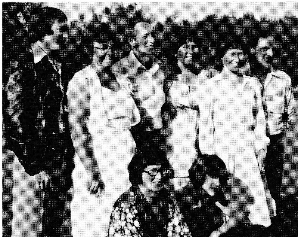 Group photograph of eight people outdoors