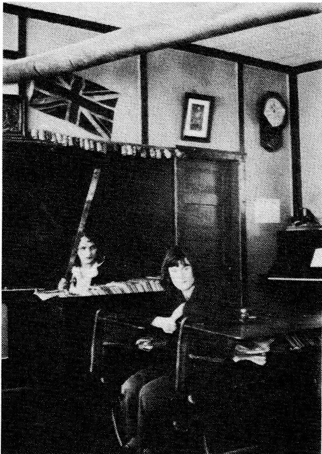 Black and white photograph of a teacher and student in a classroom