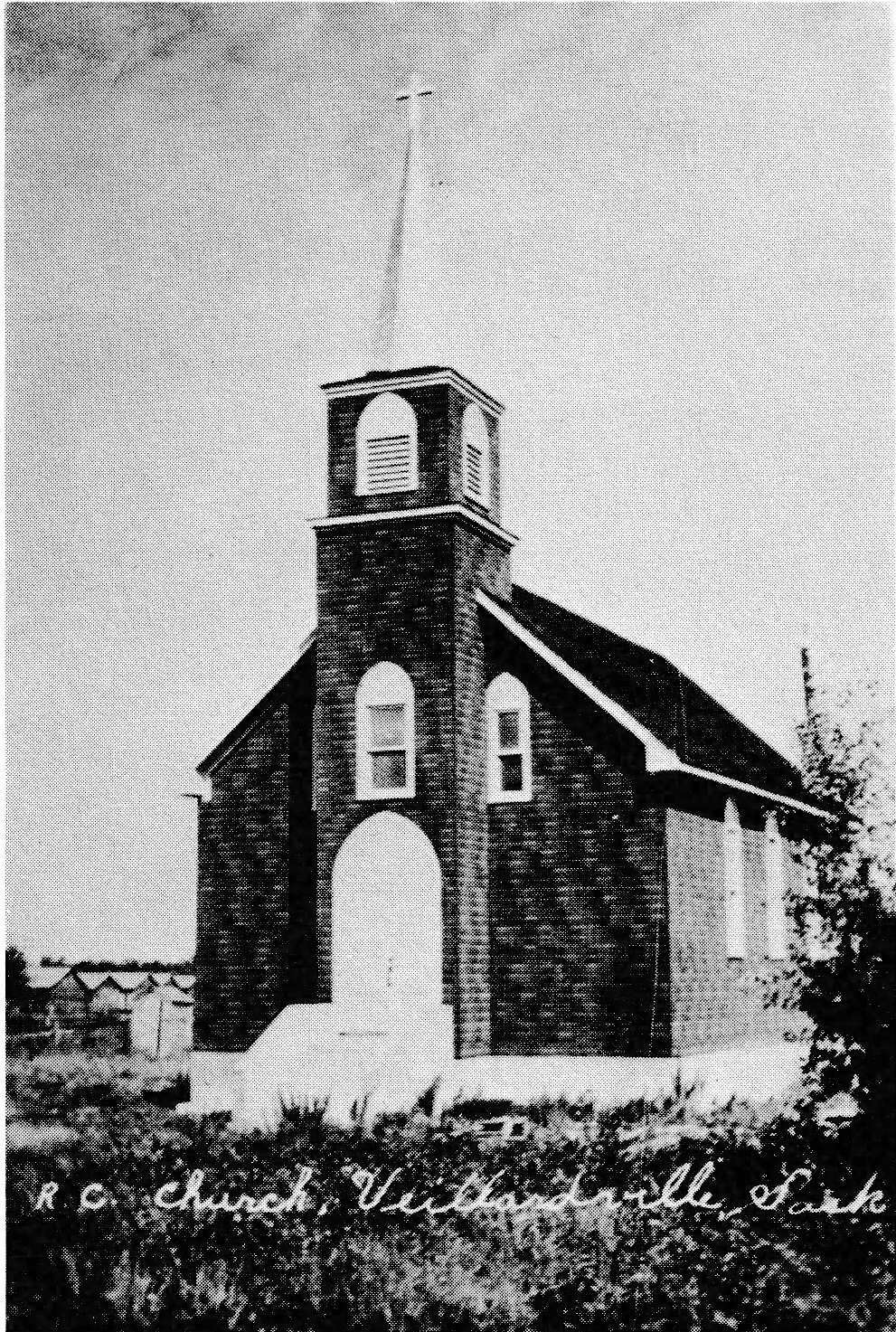 Black and white photograph of a small wooden church with a bell tower. Text on the photo reads 'R.C. Church, Veillardville, Sask.'